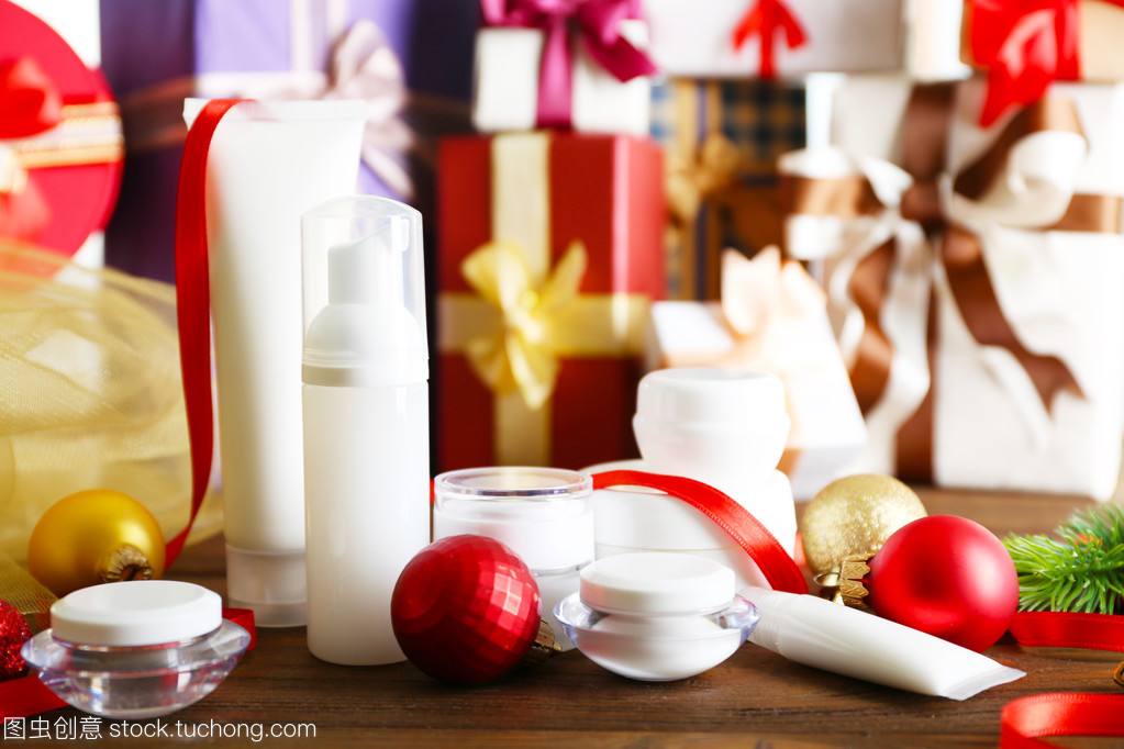 美容化妆品产品与模糊的礼品背景上的圣诞装饰